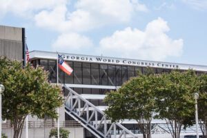 Picture of the exterior of congress center with blue sky and Georgia State flag flying