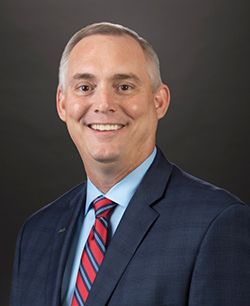 Man in suit and striped tie on black background