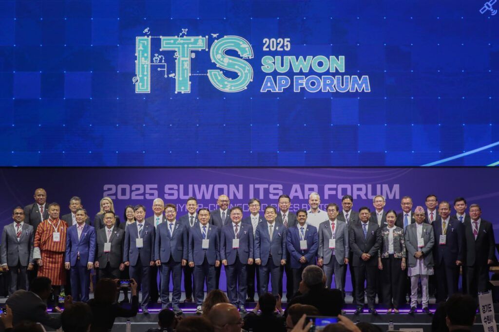 Group of people in business attire stand on stage for formal photograph