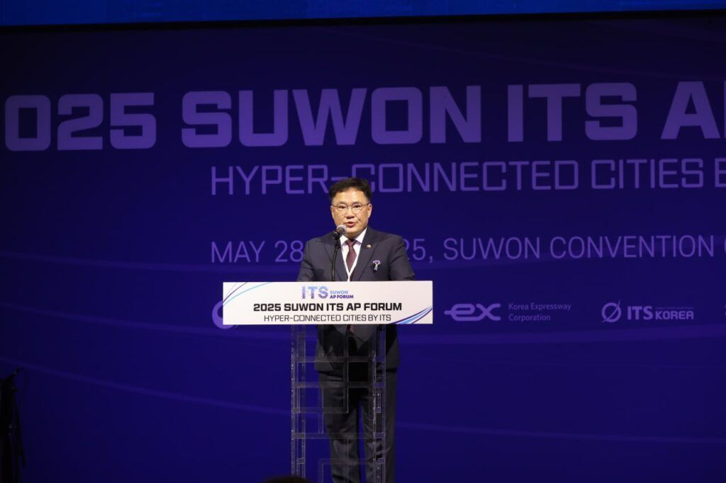 Asian man stands at podium on stage