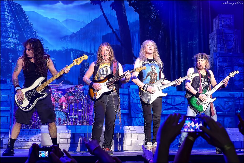 Four old men with long hair on stage with guitars
