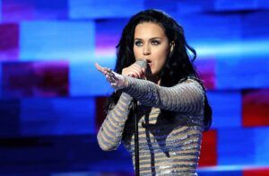 A young woman with long dark hair singing on stage