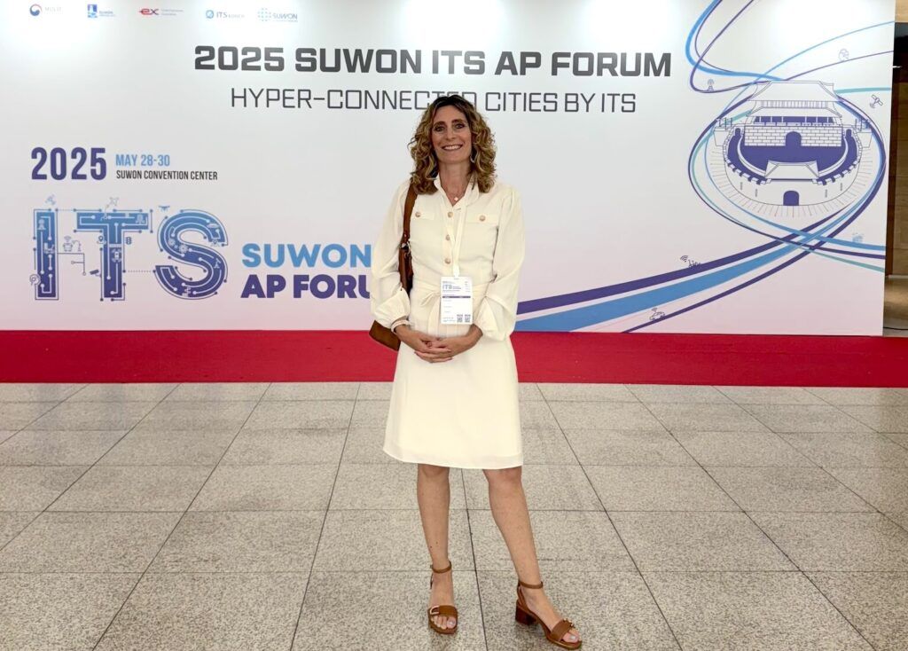 Woman in white coat stands in front of ITS sign