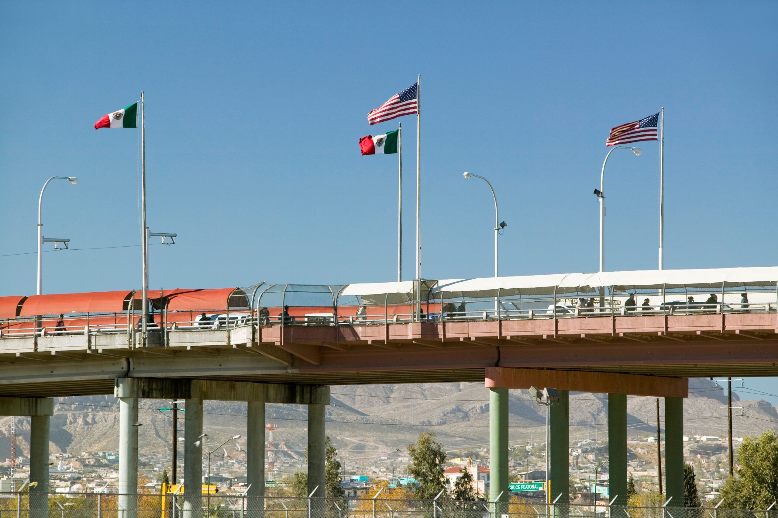 International border of Mexico &amp; the United States, with flags and walking bridge connecting El Paso Texas to Juarez, Mexico