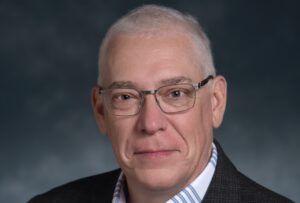 Formal picture of middle aged white man with glasses and white hair