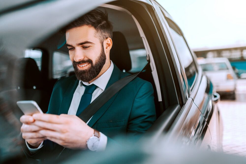 Man uses smartphone while sitting in his car
