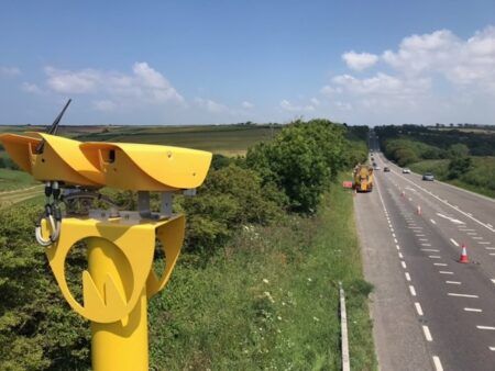 A traffic camera installed at a roadside on a sunny day