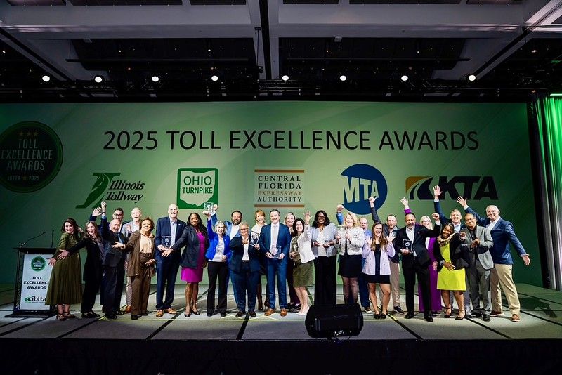 A large group of people celebrate winning an award on stage