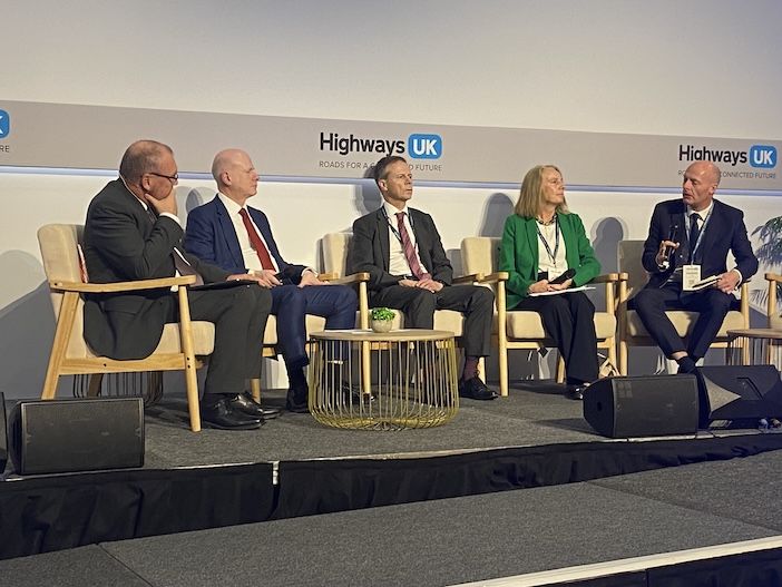 Business people on a stage at an event seated