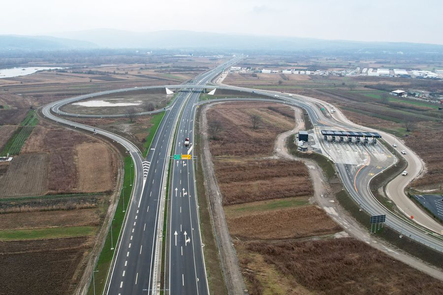 Aerial view of intersection with toll plaza controlling merging to a main highway