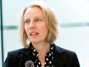 woman with blonde hair in business suit with spotty shirt