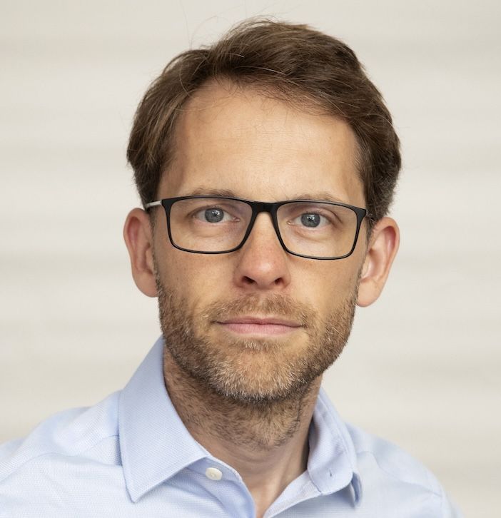 Portrait shot of caucasian man in glasses and a smart blue shirt