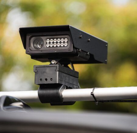 MAV Mobile ANPR camera system mounted on vehicle roof rack, showing weatherproof housing with integrated LED illumination array and camera lens