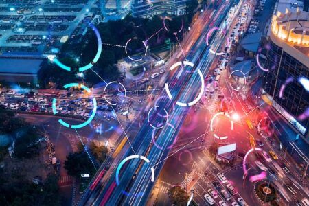 FHWA launches eighth round of Every Day Counts infrastructure innovations Abstract technology icons hologram on aerial top view of road, busy urban traffic highway at night. Junction network of transportation infrastructure. The concept of hi-tech in logistics.