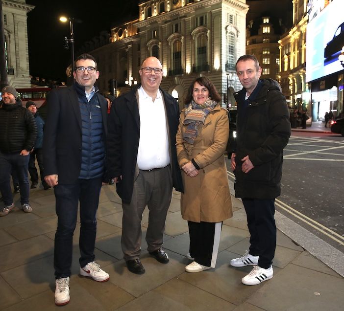 our people stand on a London pavement at night, posing for a photograph on a busy, illuminated West End street. From left: Will Norman, Cllr Adam Hug, Rachel Blake MP, and Mark Williams from the Heart of London Business Alliance
