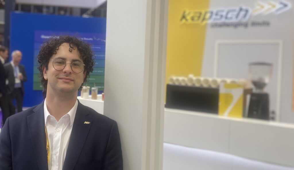 Samuel Kapsch with curly dark hair, glasses and a suit