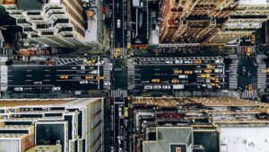 Aerial view of New York downtown building roofs. Bird's eye view from helicopter of cityscape metropolis infrastructure, traffic cars, yellow cabs moving on city streets and crossing district avenues