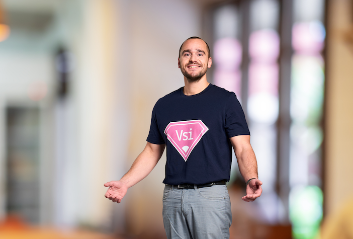 Matthias Pfriem, senior product manager for PTV Vissim, smiling and wearing a dark T-shirt with a pink "Vsi" superhero-style logo.