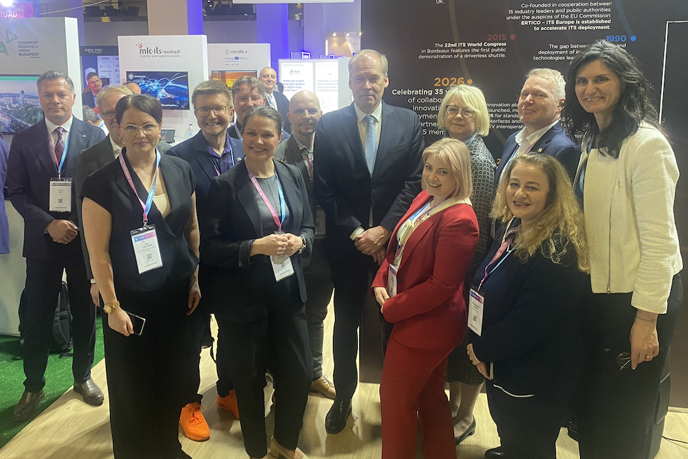 A group of around a dozen professionals pose together at an exhibition stand at the ITS European Congress in Istanbul, with signage for mlc its euskadi and Nordic+ visible in the background alongside a display marking 35 years of ERTICO. Estonian ambassador Väino Reinart stands in the centre of the group, with Finnish ambassador Pirkko Hämäläinen to his left.