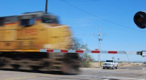 Train passing through a crossing with a car in the background
