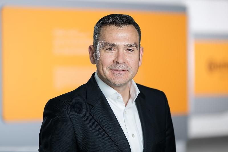 Professional shot of white man in dark suit with open neck white shirt