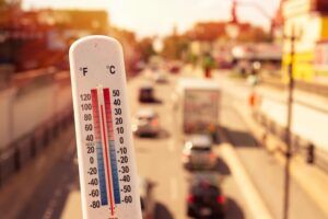 Thermometer in front of cars and traffic during heatwave in Montreal.Record temperatures are placing increasing strain on highway infrastructure across the UK.