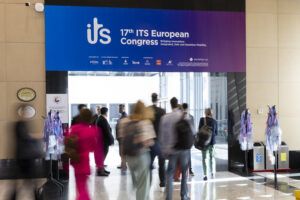 Attendees walking through an entrance beneath a large overhead banner reading "17th ITS European Congress – Bridging Innovation: Integrated, Safe and Seamless Mobility," with organiser and sponsor logos displayed below the title