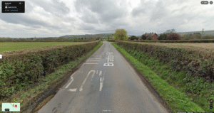 Google Street View image of Bratton Road near Westbury, Wiltshire, in March 2024, showing hedges trimmed back from the carriageway with a clear sightline towards the junction