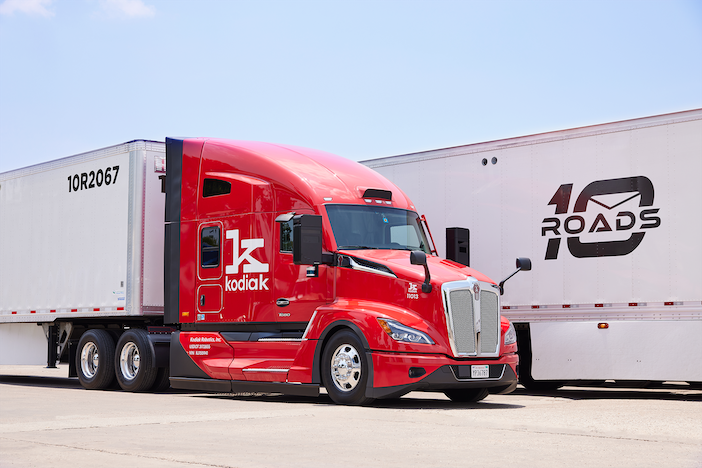 PrePass, Kodiak link driverless trucks to roadside checks A red truck cab with "Kodiak" and "K" logos on the door, parked between two trailers, one marked