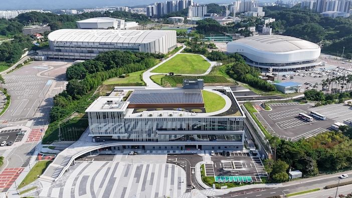 Aerial view of the Gangneung Convention Center surrounded by green space, car parks and two large white-roofed arenas