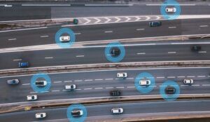Aerial view of a multi-lane motorway with several cars, each surrounded by a glowing blue circle.