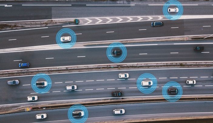 Aerial view of a multi-lane motorway with several cars, each surrounded by a glowing blue circle.