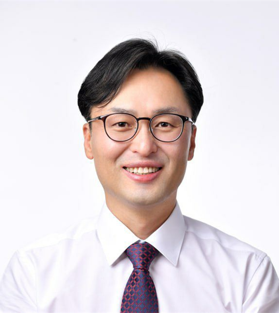 Headshot portrait of Heo Cheong-hoe, president of ITS Korea, wearing glasses and a patterned tie, against a plain light grey background