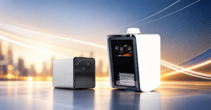 wo compact camera units, one silver and black and one white and black, stand on a reflective surface in front of a blurred city skyline with glowing light trails.